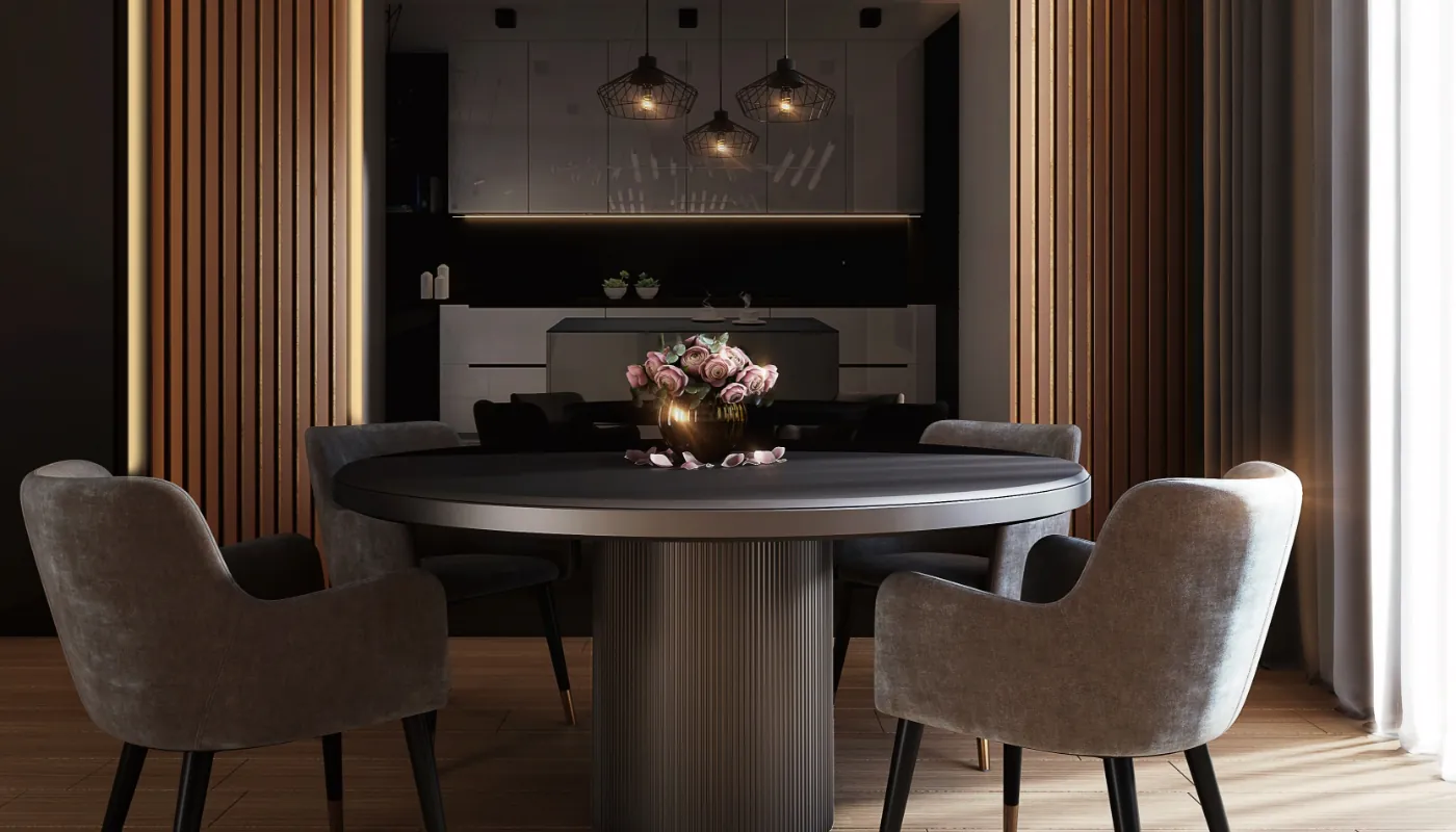 Elegancka jadalnia z okrągłym ciemnym stołem, czterema szarymi tapicerowanymi fotelami i złotą wazą z różowymi różami na środku; w tle ciemna kuchnia z trzema wiszącymi drucianymi lampami, pionowymi drewnianymi panelami i zasłoną przepuszczającą światło.