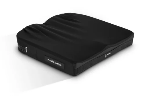 Czarna profilowana poduszka ortopedyczna o prostokątnym kształcie z falistymi wgnieceniami na górnej powierzchni, teksturowanymi bokami i widoczną naszywką z logo, ustawiona na białym tle.