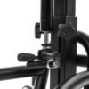 Czarny fragment metalowego stelaża z pionowym profilem, gwiaździstym pokrętłem, dwoma cylindrycznymi pokrętłami i śrubowym zaciskiem łączącym zakrzywione rury.
