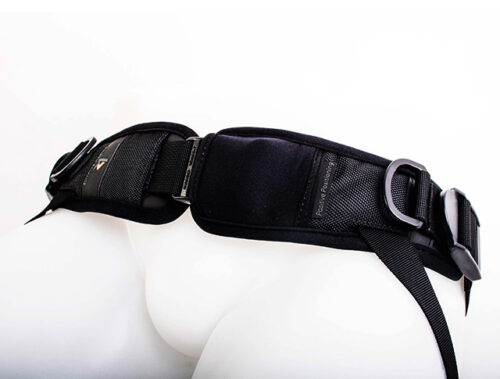 Czarny wyściełany pas biodrowy z klamrami, regulowanymi taśmami i półokrągłymi metalowymi uchwytami, założony na biały manekin dolnej części tułowia.