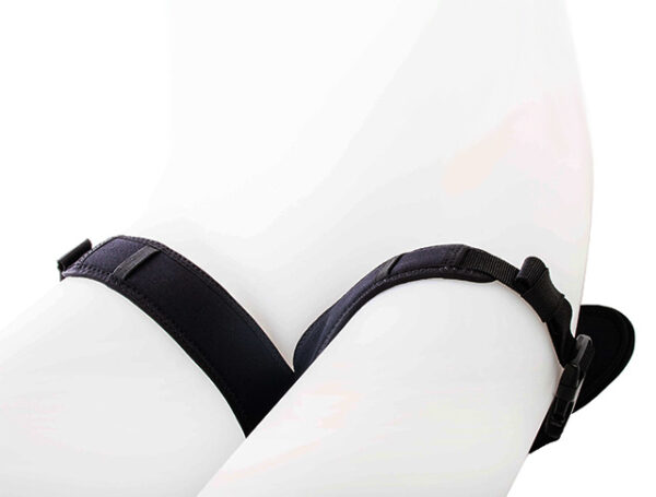 Białe uda manekina oplecione czarnymi regulowanymi pasami z zapinkami na jednolitym jasnym tle.