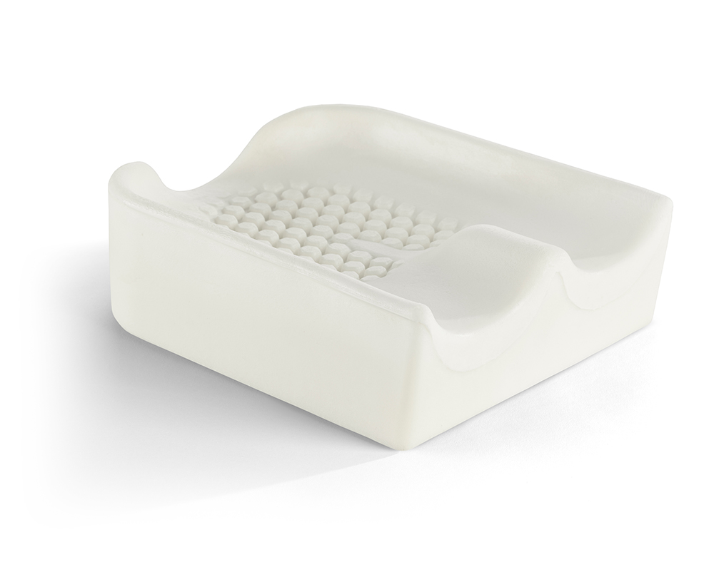 Profilowana biała piankowa podpórka ortopedyczna z wyprofilowanymi zagłębieniami i teksturowanym centralnym polem.