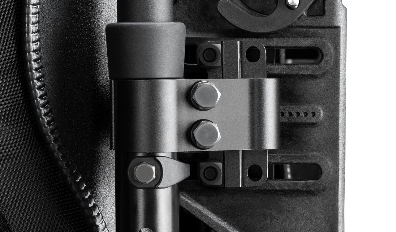 Zbliżenie metalowego uchwytu ze spinką i trzema śrubami sześciokątnymi na teksturowanym czarnym plastiku.